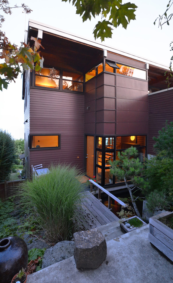 Medium sized and brown contemporary detached house in Seattle with three floors, concrete fibreboard cladding, a pitched roof and a mixed material roof.