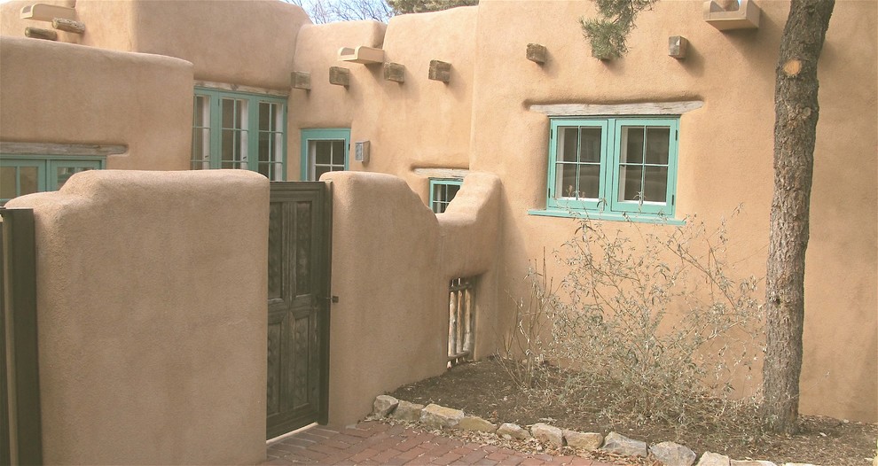 Exemple d'une grande façade de maison marron sud-ouest américain en adobe à un étage avec un toit à deux pans et un toit mixte.
