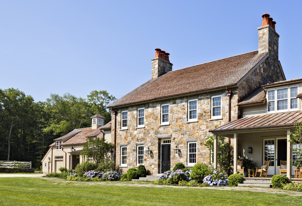 Geräumiges, Zweistöckiges Landhaus Haus mit Steinfassade, beiger Fassadenfarbe und Satteldach