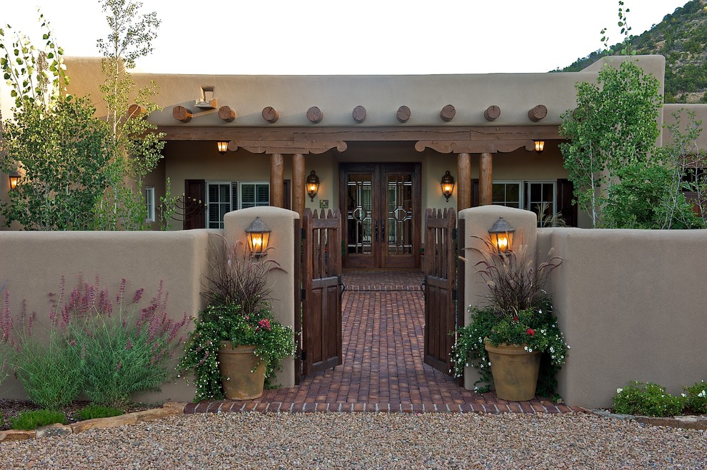 Mittelgroßes, Einstöckiges Klassisches Haus mit Lehmfassade, brauner Fassadenfarbe und Flachdach in Albuquerque