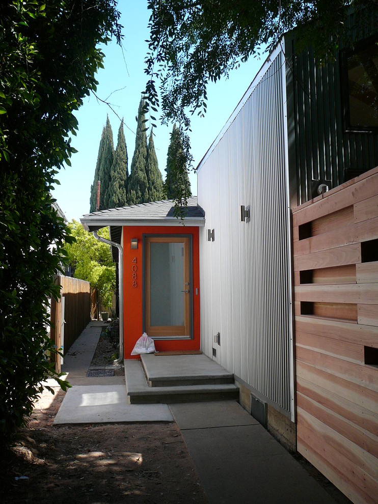 Small and gey urban bungalow house exterior in Los Angeles with metal cladding and a pitched roof.