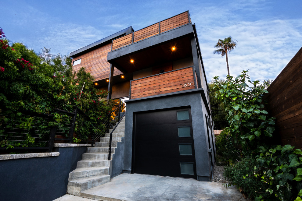 Idée de décoration pour une façade de maison multicolore minimaliste en bois de taille moyenne et à un étage avec un toit plat et un toit végétal.