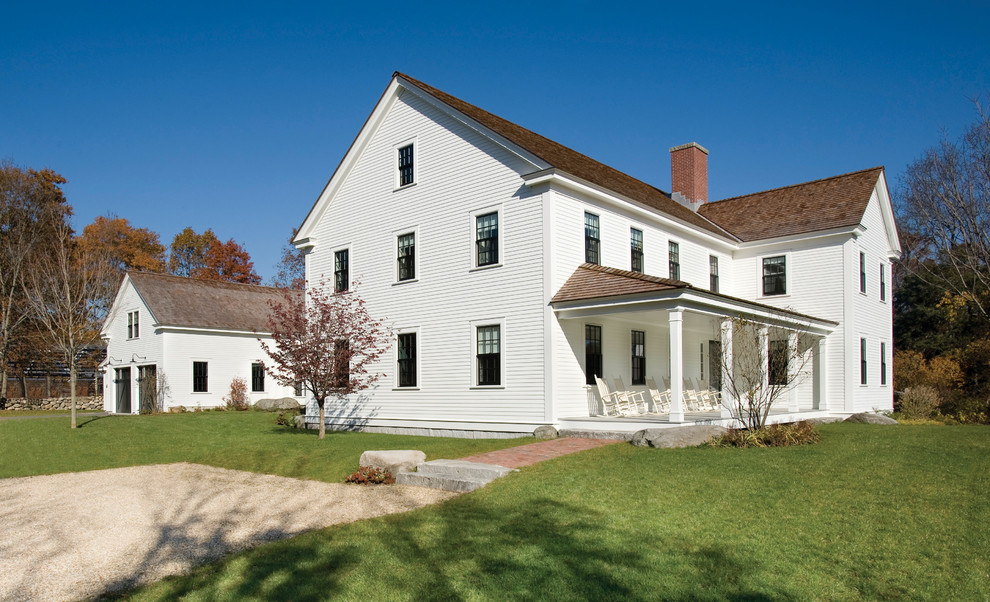 Immagine della facciata di una casa grande bianca country a due piani con rivestimento in legno