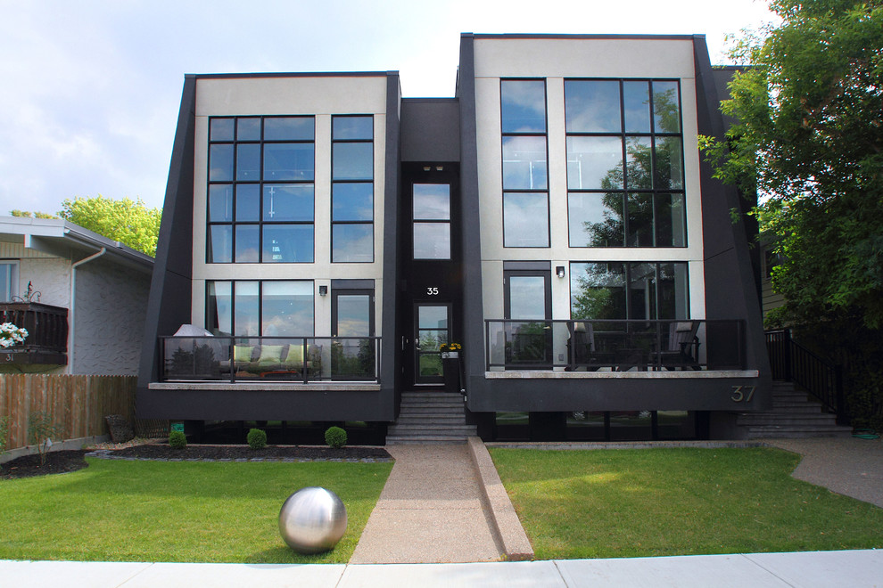 Zweistöckiges, Großes Modernes Haus mit schwarzer Fassadenfarbe, Flachdach und Faserzement-Fassade in Calgary
