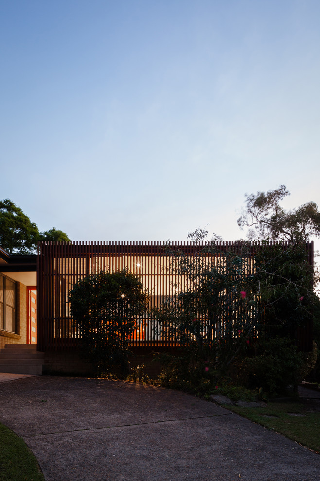 Medium sized and brown contemporary bungalow house exterior in Sydney with wood cladding.