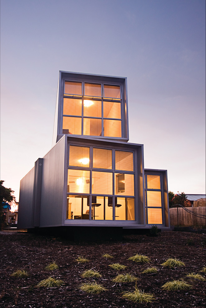 На фото: двухэтажный, серый дом в стиле лофт с облицовкой из ЦСП и плоской крышей с