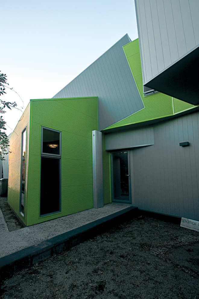 Foto på ett litet industriellt grått hus i flera nivåer, med fiberplattor i betong
