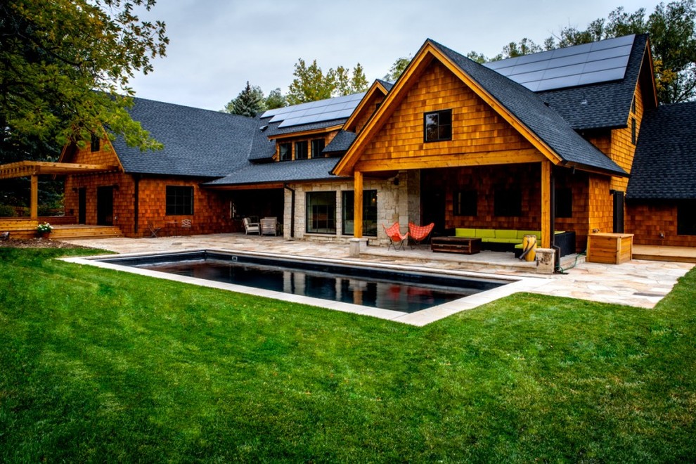 Exemple d'une grande façade de maison beige montagne en bois à un étage avec un toit à quatre pans.