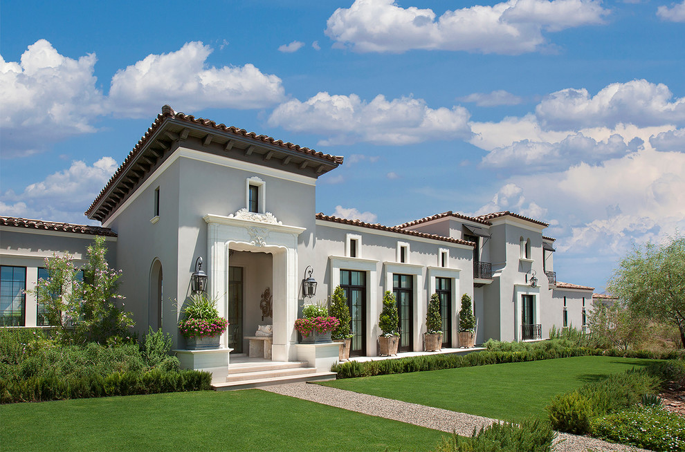 Imagen de fachada de casa beige mediterránea grande de dos plantas con revestimiento de estuco, tejado a dos aguas y tejado de teja de barro