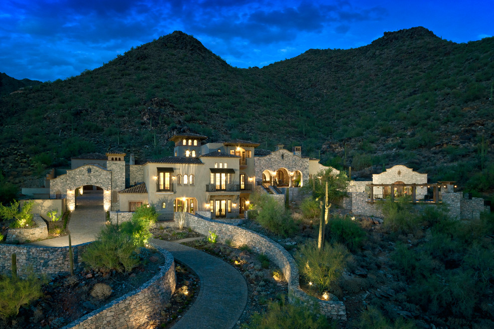 Inspiration for a large mediterranean beige three-story mixed siding gable roof remodel in Phoenix
