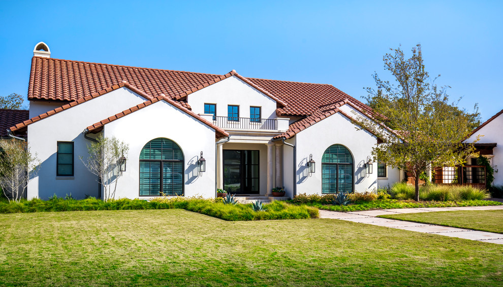 Diseño de fachada de casa blanca mediterránea extra grande de dos plantas con revestimiento de estuco y tejado de teja de barro