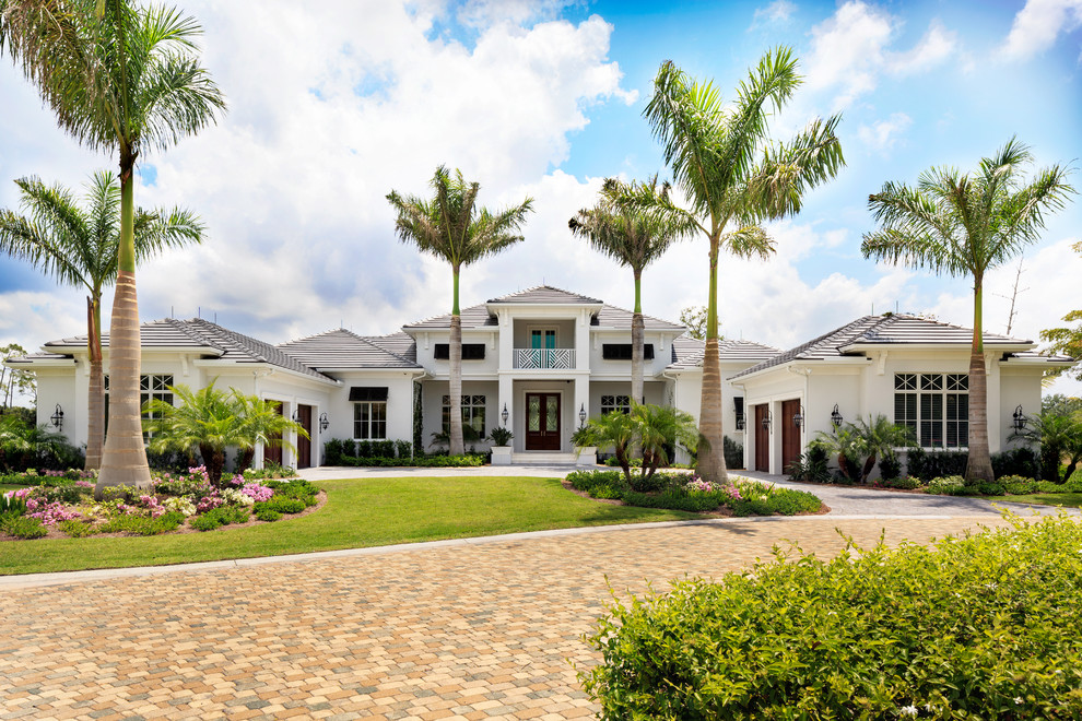Huge beach style white one-story house exterior photo in Miami with a hip roof and a tile roof