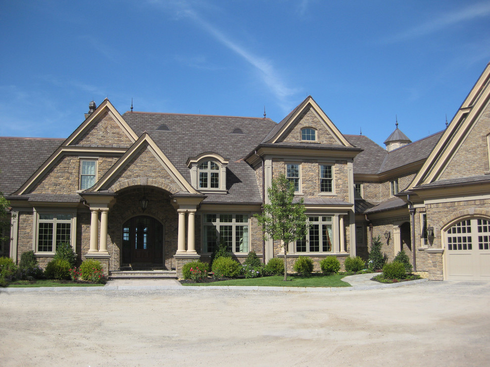 Idee per la villa ampia marrone american style a tre piani con rivestimento in pietra, tetto a capanna e copertura in tegole