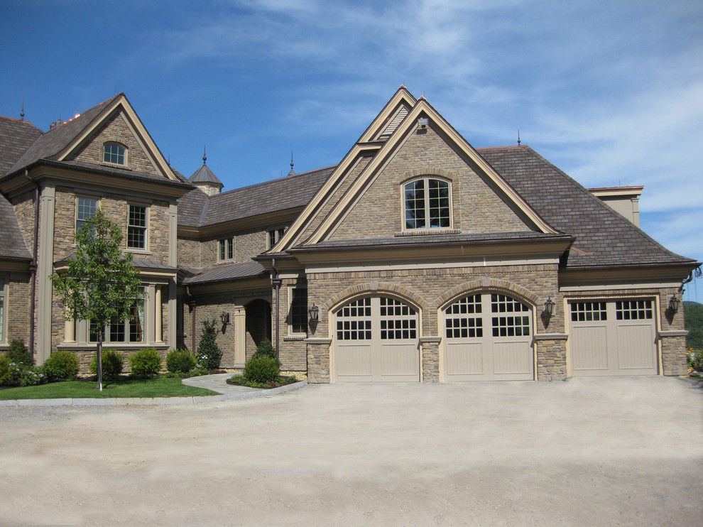 Ispirazione per la villa ampia marrone american style a tre piani con rivestimento in pietra, tetto a capanna e copertura in tegole