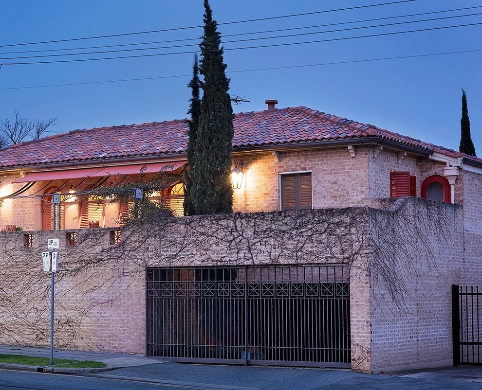 Idée de décoration pour une façade de maison méditerranéenne en brique de taille moyenne et à un étage.