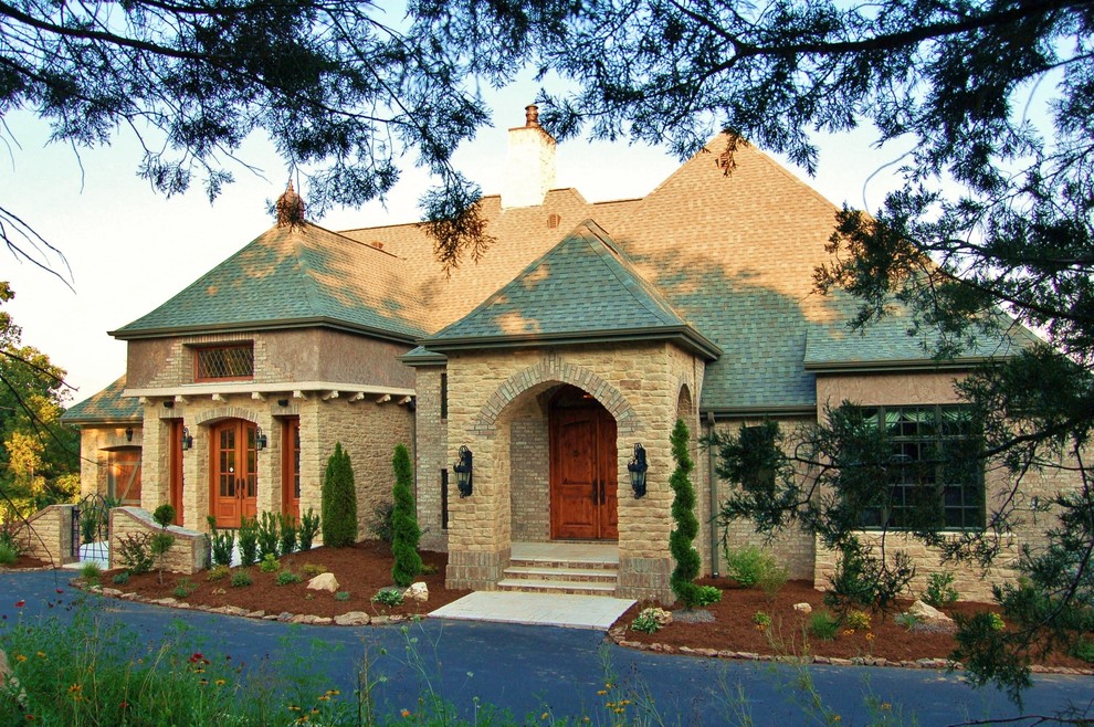 Photo of a large and brown mediterranean two floor house exterior in Other with mixed cladding and a hip roof.