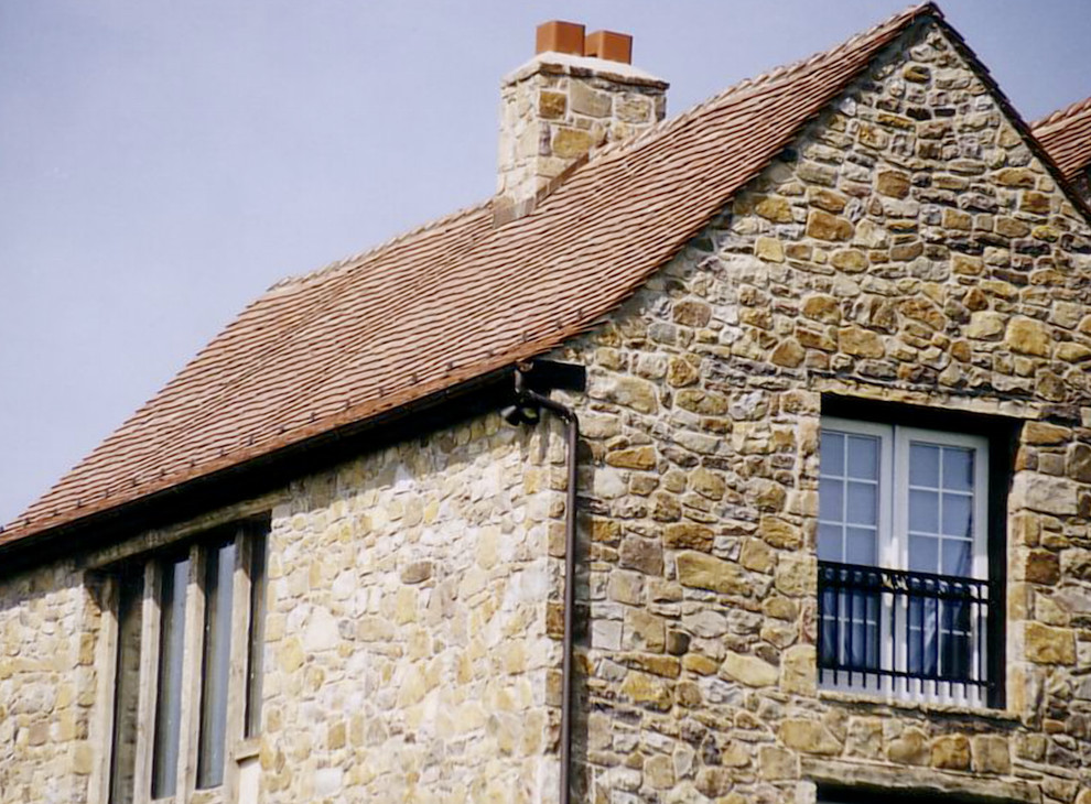 Exemple d'une grande façade de maison beige chic en stuc à un étage avec un toit à deux pans et un toit en shingle.