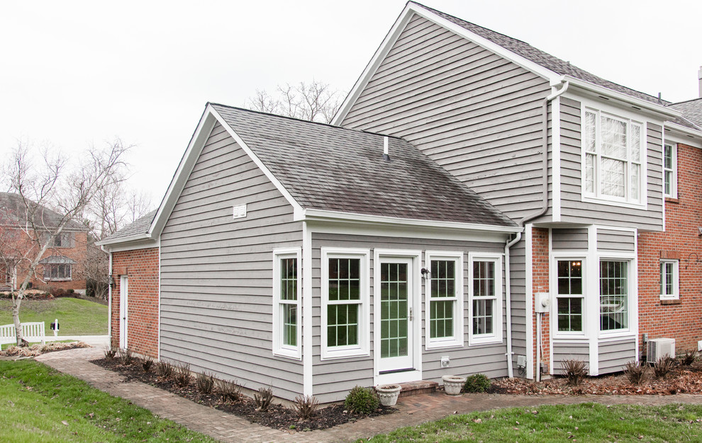 Ejemplo de fachada de casa gris tradicional renovada grande de una planta con revestimientos combinados, tejado a dos aguas y tejado de teja de madera