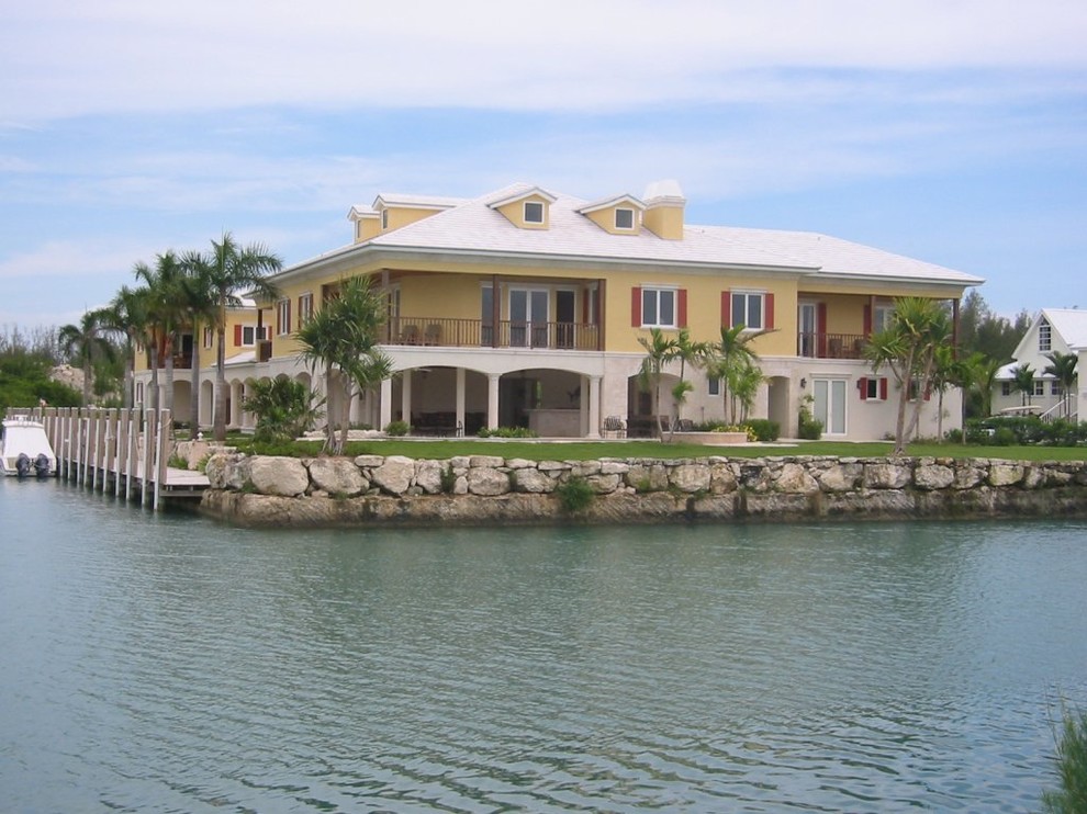 Ispirazione per la facciata di una casa ampia gialla tropicale a tre piani con rivestimento in stucco