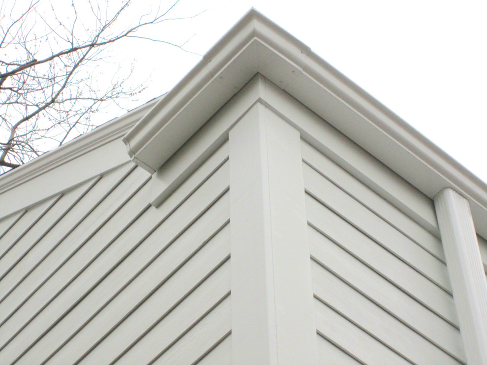 This is an example of a medium sized and white traditional two floor house exterior in Chicago with concrete fibreboard cladding.