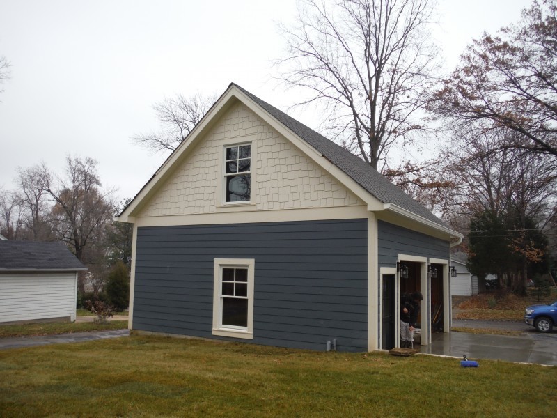 Immagine della facciata di una casa grande blu a due piani con rivestimento con lastre in cemento