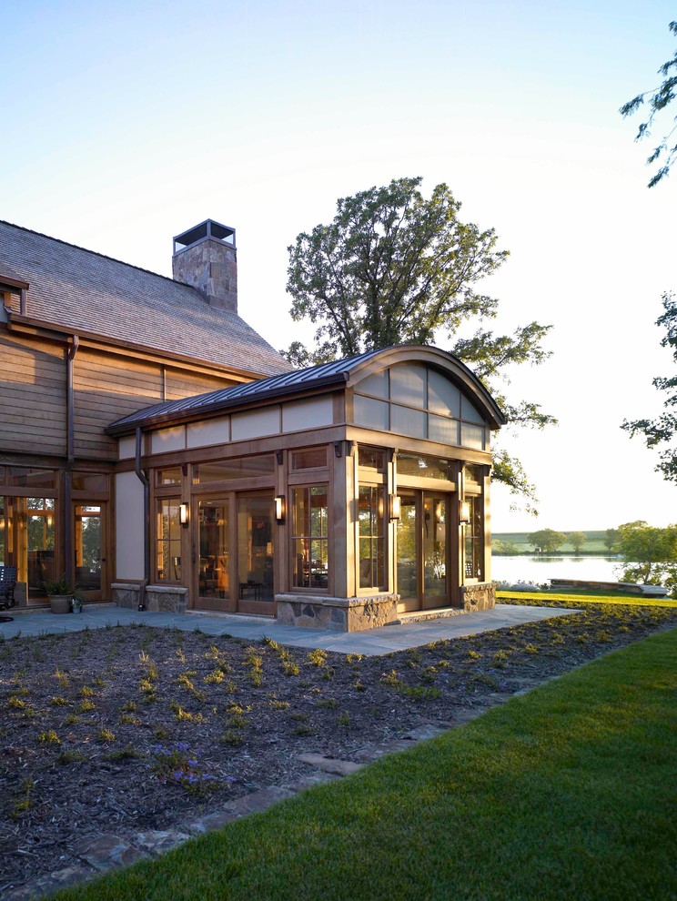 Idee per la villa ampia marrone rustica a tre piani con rivestimento in legno, tetto a capanna e copertura in tegole