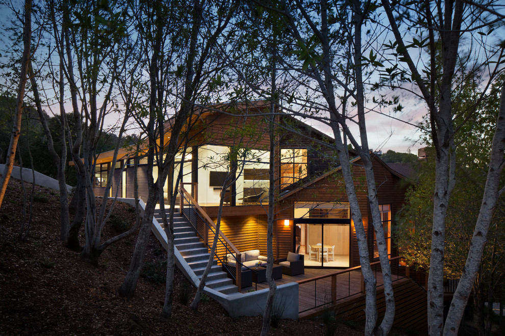 Cette image montre une grande façade de maison marron design en bois à deux étages et plus avec un toit en shingle.