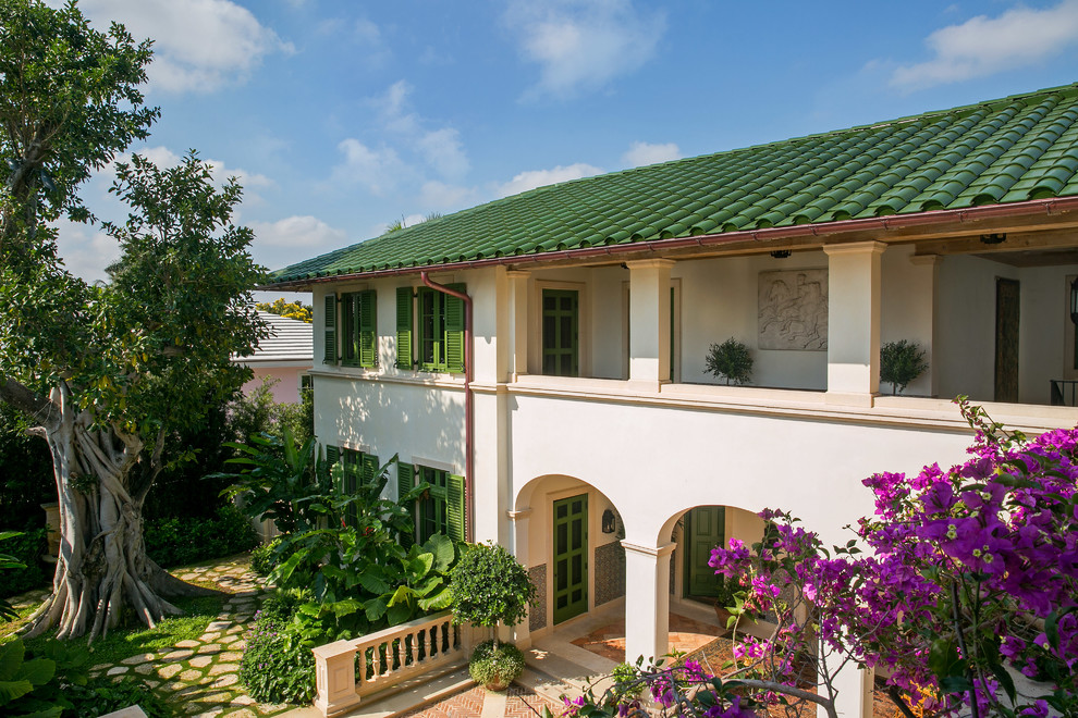 На фото: огромный, двухэтажный, белый частный загородный дом в средиземноморском стиле с облицовкой из цементной штукатурки, вальмовой крышей и черепичной крышей