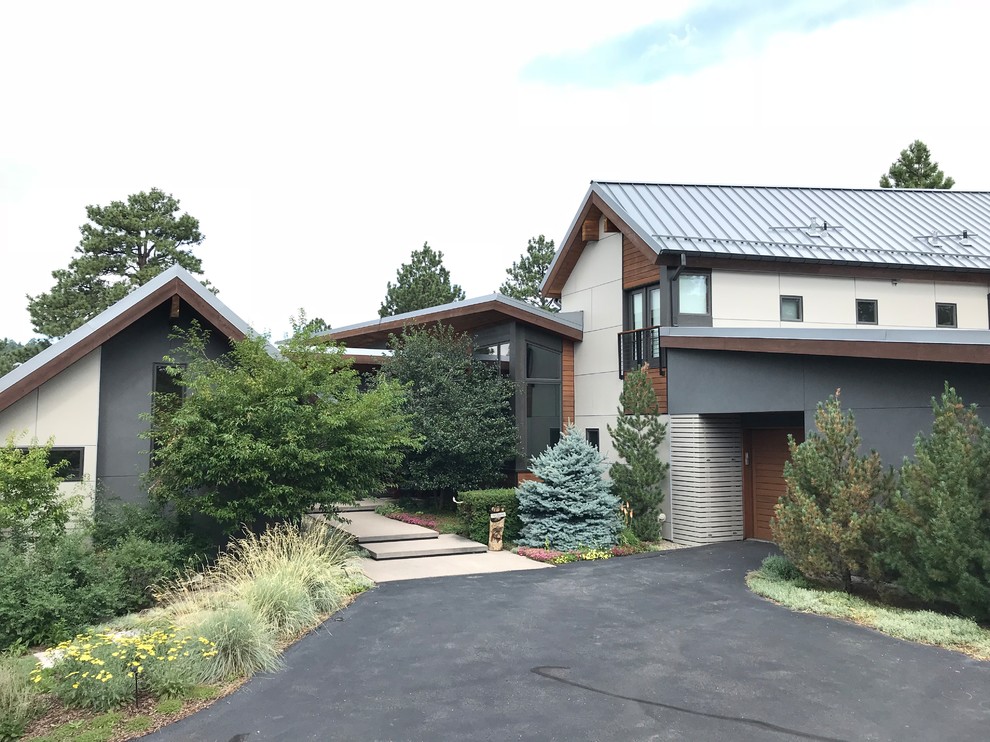 Photo of a gey contemporary render detached house in Denver with a metal roof.