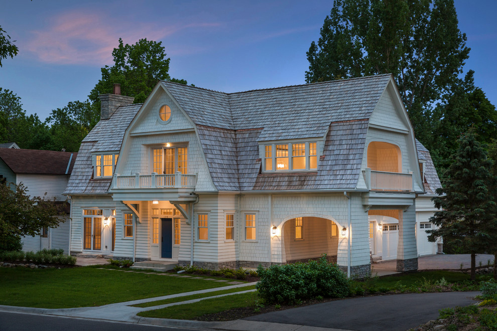 Imagen de fachada de casa blanca costera de dos plantas con revestimiento de aglomerado de cemento, tejado a doble faldón y tejado de teja de madera