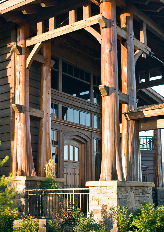 Diseño de fachada marrón rústica extra grande de tres plantas con revestimiento de madera y tejado a dos aguas