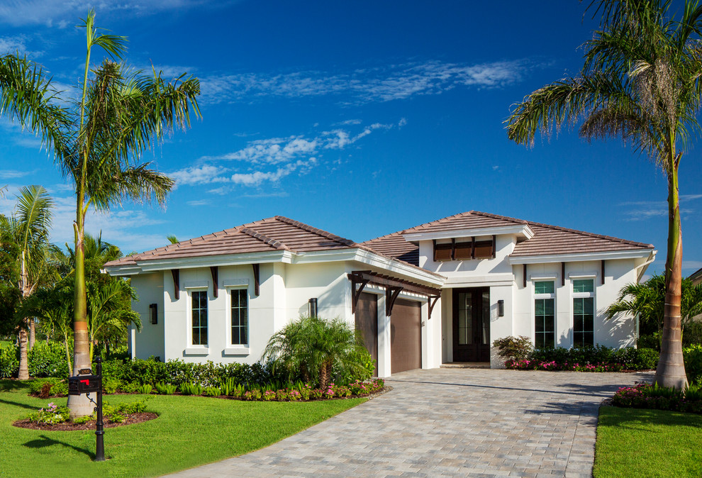 Diseño de fachada de casa blanca tropical de una planta con tejado a cuatro aguas y tejado de teja de barro