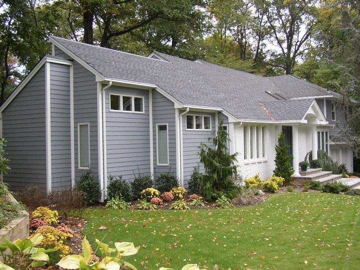 Photo of a medium sized and gey traditional bungalow detached house in New York with a pitched roof, a shingle roof and vinyl cladding.