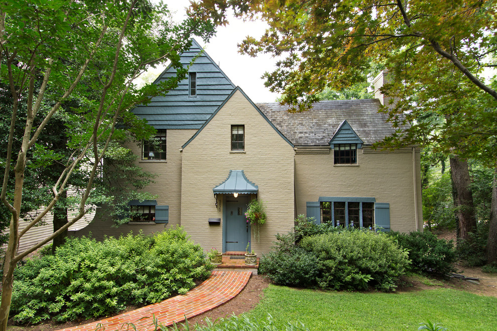 Exemple d'une façade de maison beige chic en brique.