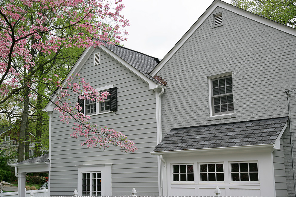 На фото: большой, трехэтажный, серый дом в классическом стиле с облицовкой из ЦСП и двускатной крышей