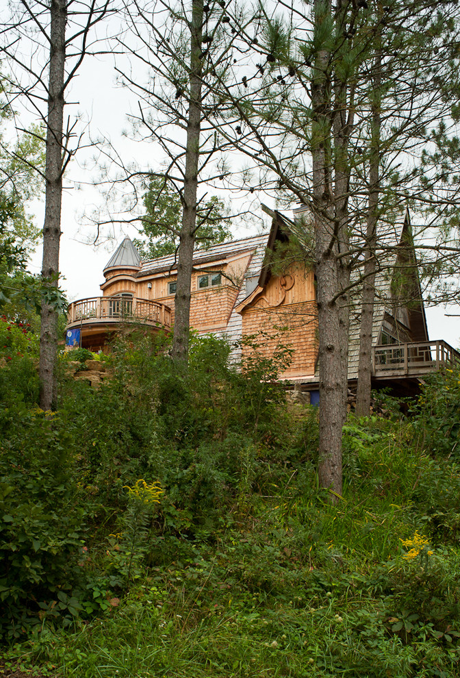 Aménagement d'une grande façade de maison marron éclectique en bois à deux étages et plus avec un toit à deux pans, un toit en shingle et un toit marron.