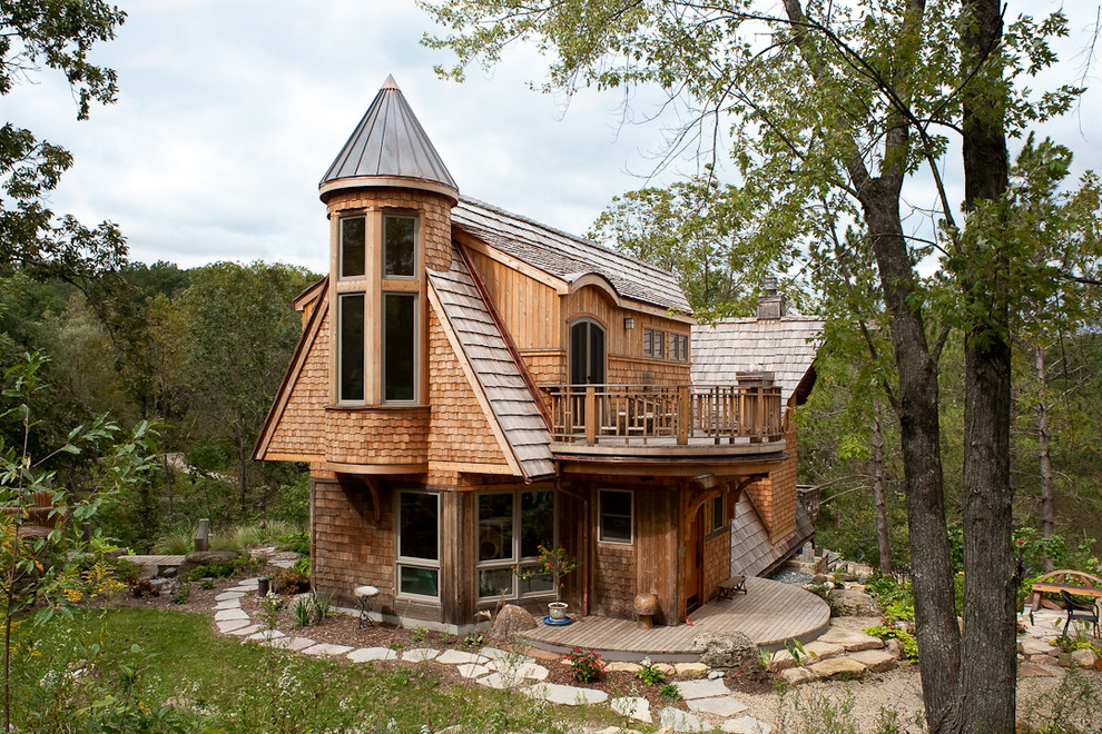 На фото: деревянный, большой, трехэтажный, коричневый частный загородный дом в стиле фьюжн с двускатной крышей, крышей из гибкой черепицы и коричневой крышей с