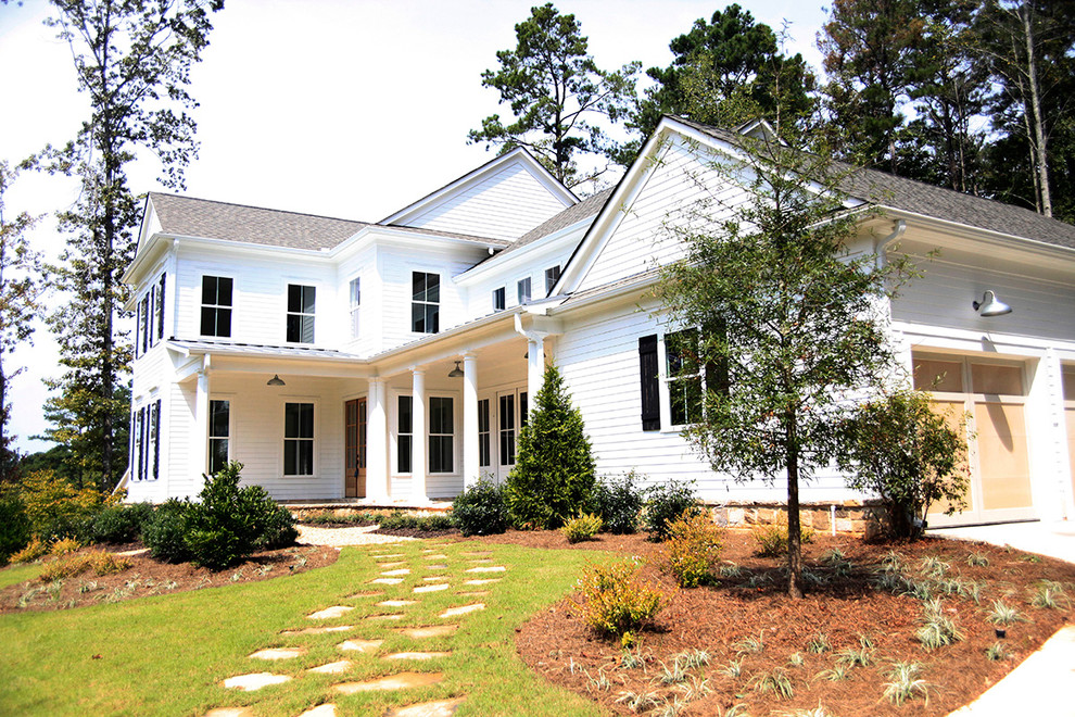 Cette photo montre une façade de maison blanche chic en panneau de béton fibré de taille moyenne et à un étage avec un toit à deux pans.