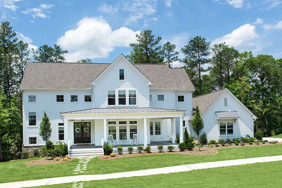 Immagine della facciata di una casa bianca country a due piani di medie dimensioni con rivestimento con lastre in cemento e tetto a capanna