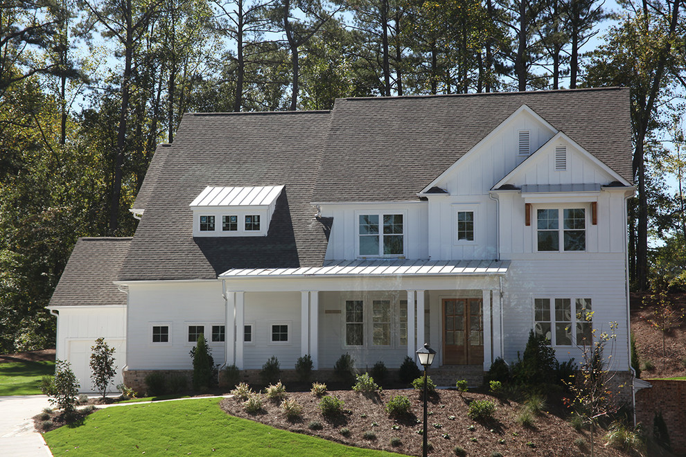 Ejemplo de fachada blanca de estilo de casa de campo de tamaño medio de dos plantas con revestimientos combinados y tejado a dos aguas