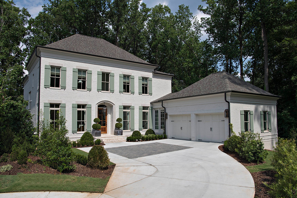 Foto della facciata di una casa grande bianca classica a due piani con rivestimento in mattoni e tetto a padiglione