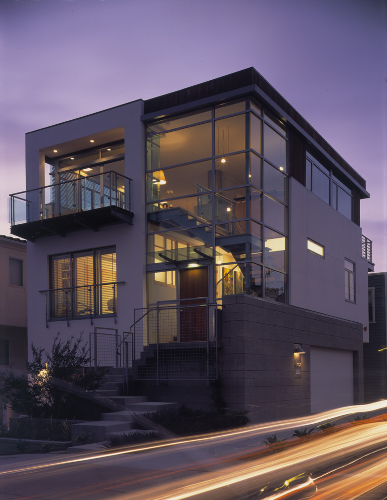 This is an example of a large and white contemporary render detached house in Los Angeles with three floors and a flat roof.