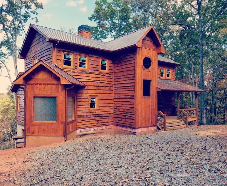 Photo of a large and brown rustic detached house in Atlanta with three floors, wood cladding, a pitched roof and a metal roof.