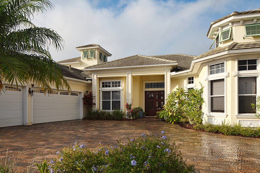Island style beige two-story stucco house exterior photo in Orlando