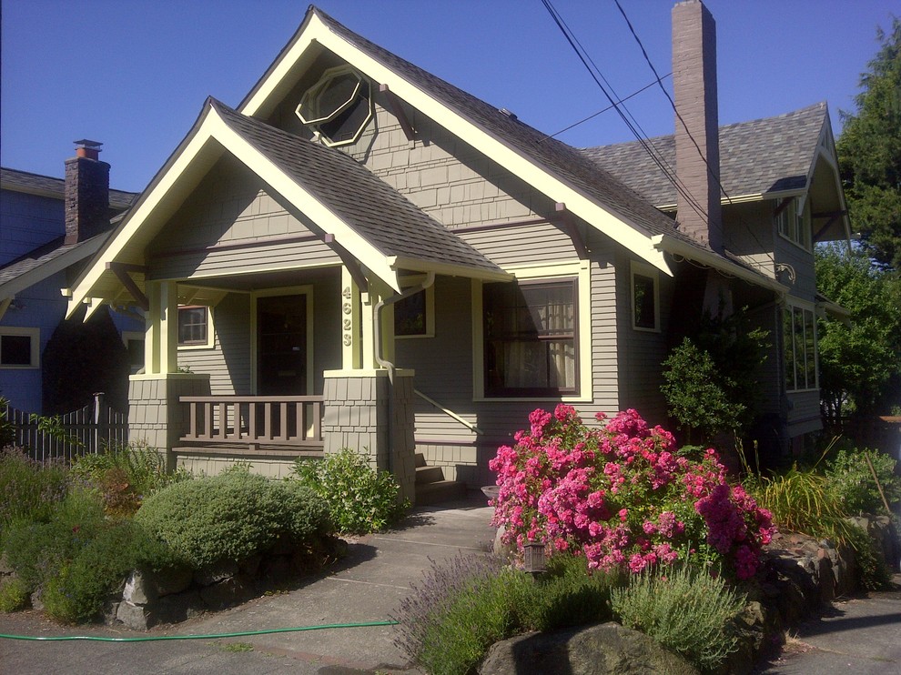 Medium sized and gey traditional two floor house exterior in Seattle with wood cladding.