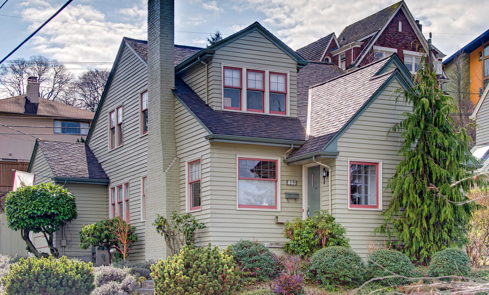 Esempio della facciata di una casa verde classica a due piani di medie dimensioni con rivestimento in legno e abbinamento di colori