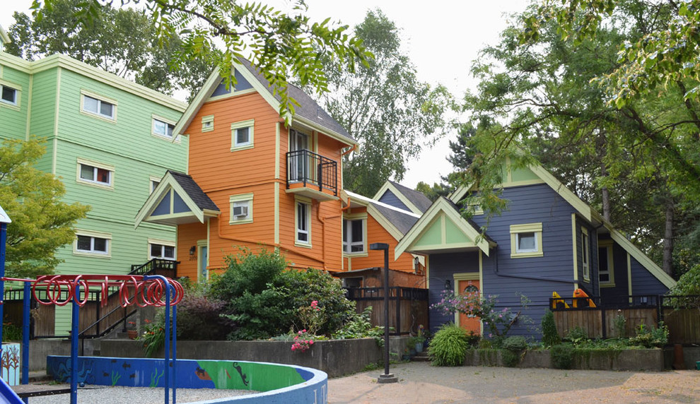 Foto på ett mycket stort eklektiskt flerfärgat radhus, med tre eller fler plan, vinylfasad och sadeltak