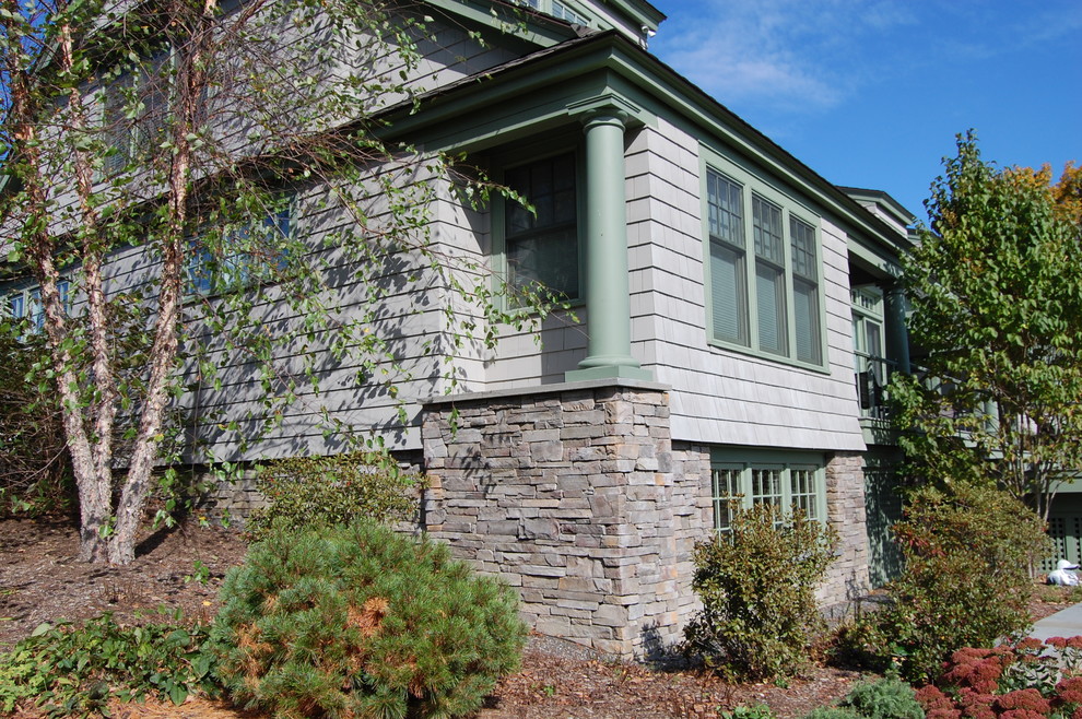 Exempel på ett stort klassiskt grått hus i flera nivåer, med fiberplattor i betong och halvvalmat sadeltak
