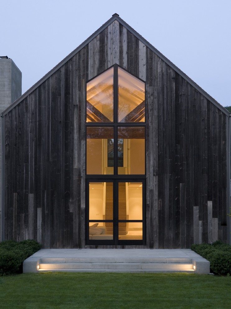 Ejemplo de fachada clásica renovada de dos plantas con revestimiento de madera