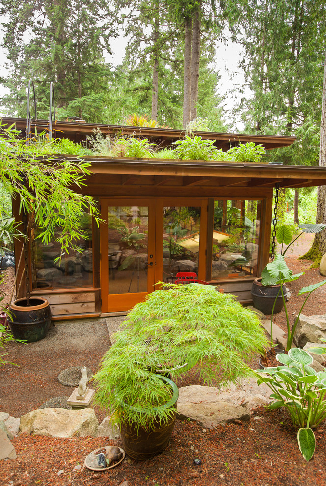 Inspiration for a contemporary one-story wood exterior home remodel in Other with a green roof
